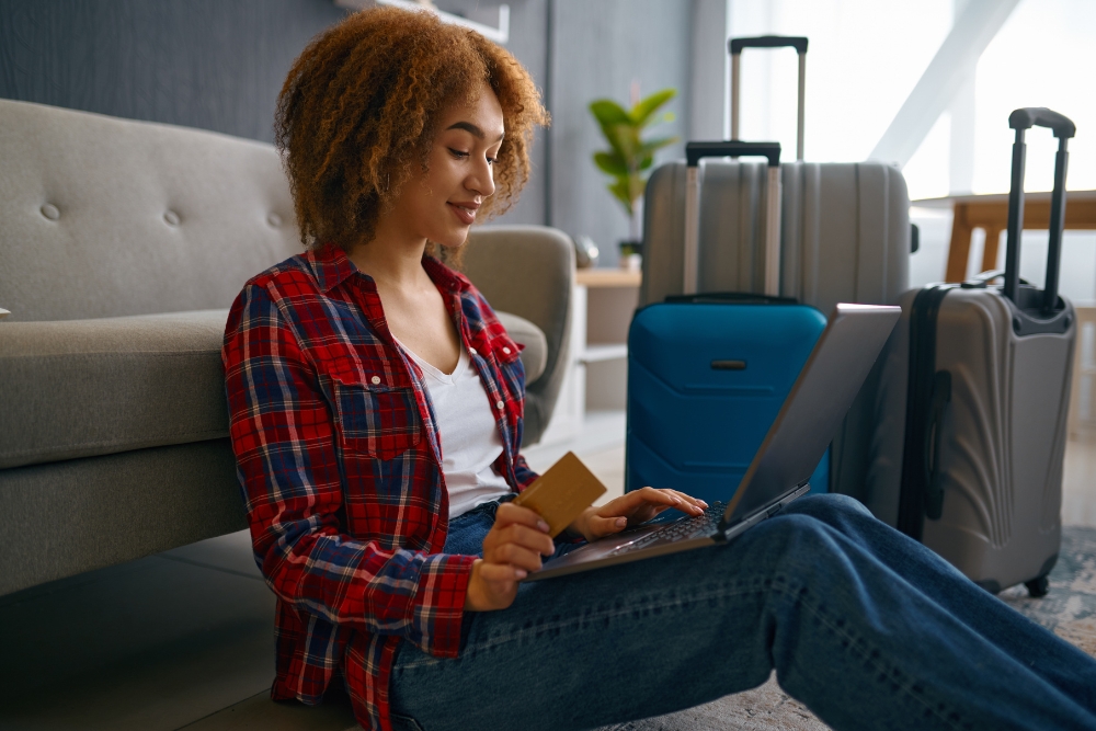 A woman sitting on her laptop plans a trip.